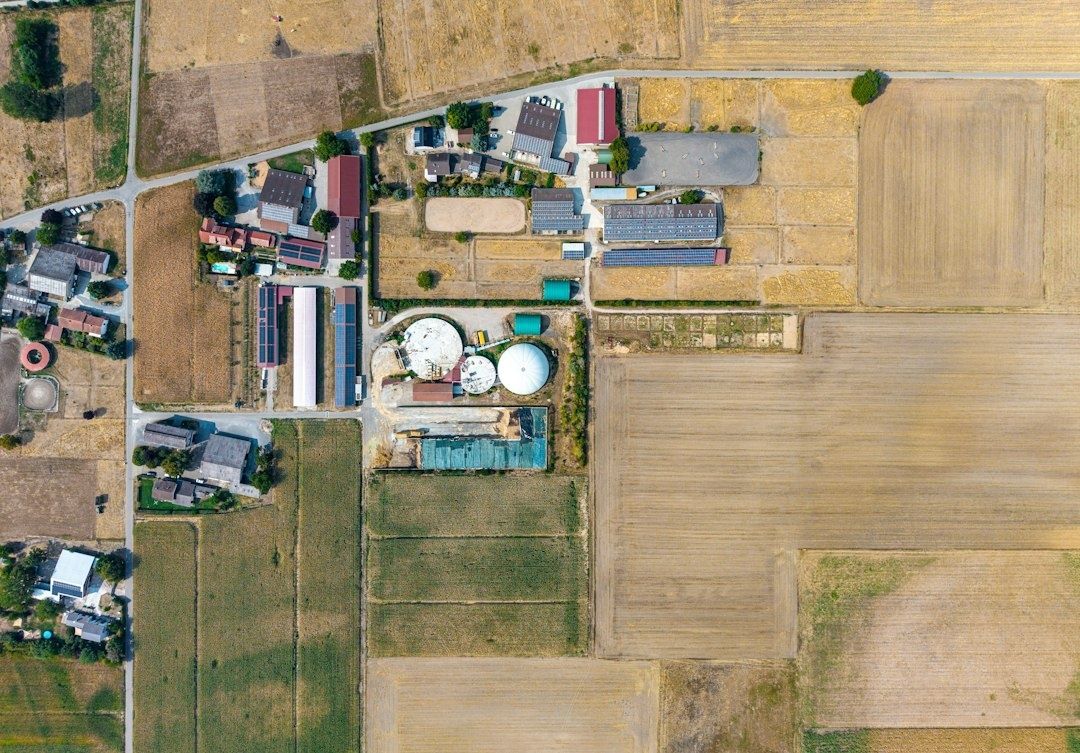 Drohnenansicht einer Biogasanlage zwischen landwirtschaftlichen Feldern